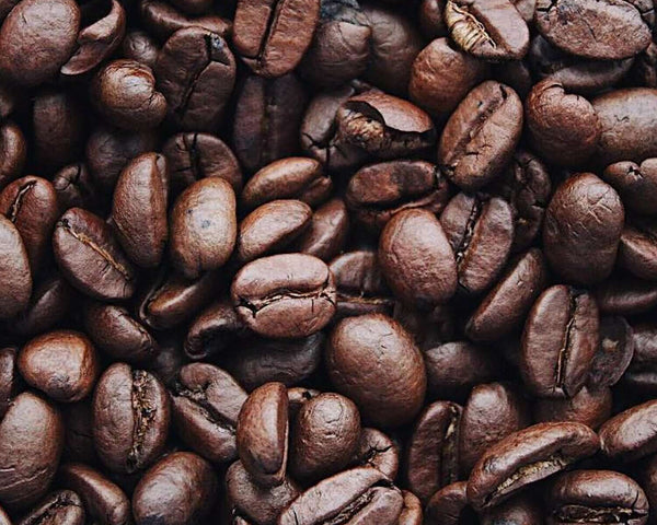 Coffee beans representing caffeine, which improves hair growth rate, rivaling minoxidil's effectiveness.