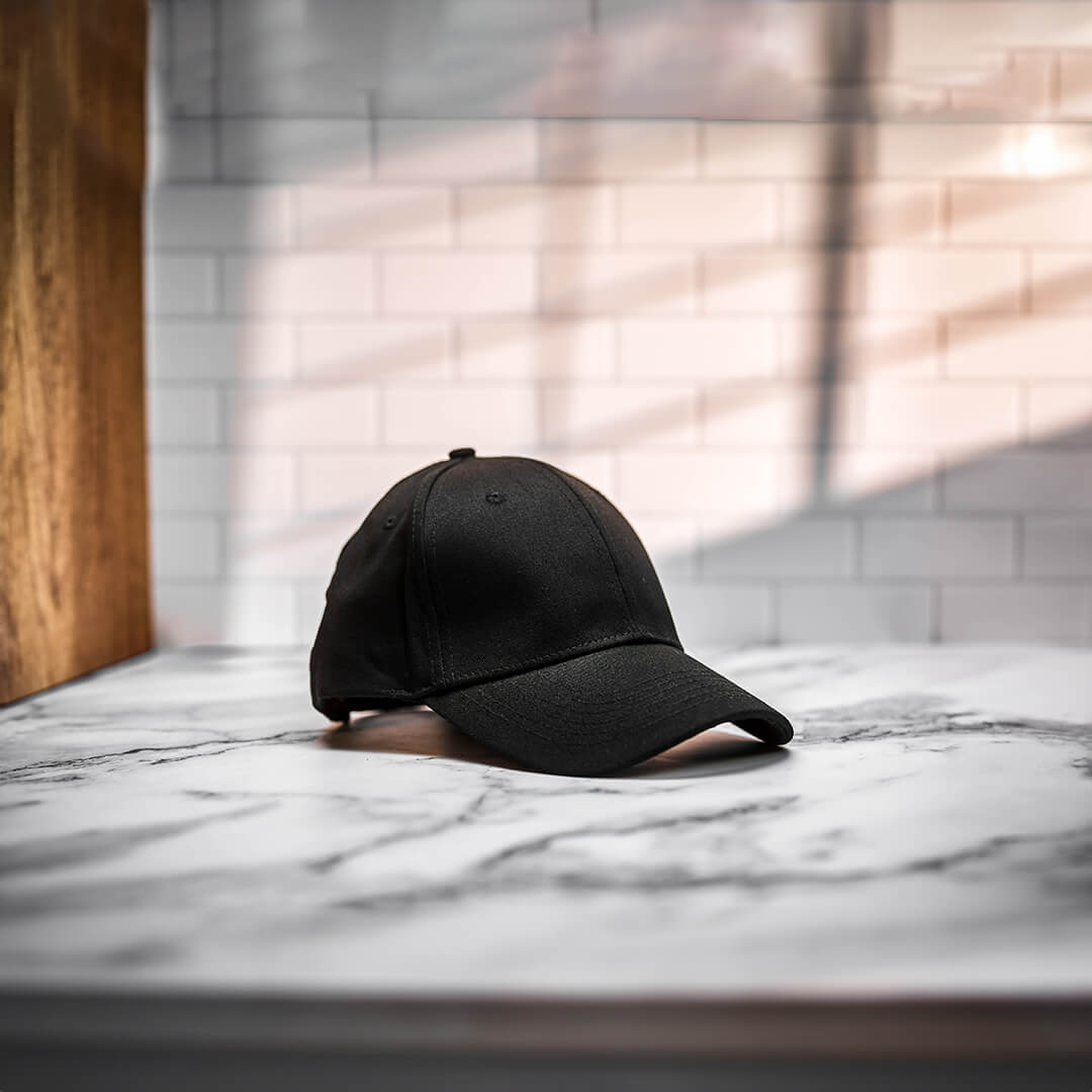 Elegant photoshoot image of a silk-lined hat placed on a marble surface, emphasizing its stylish appearance.